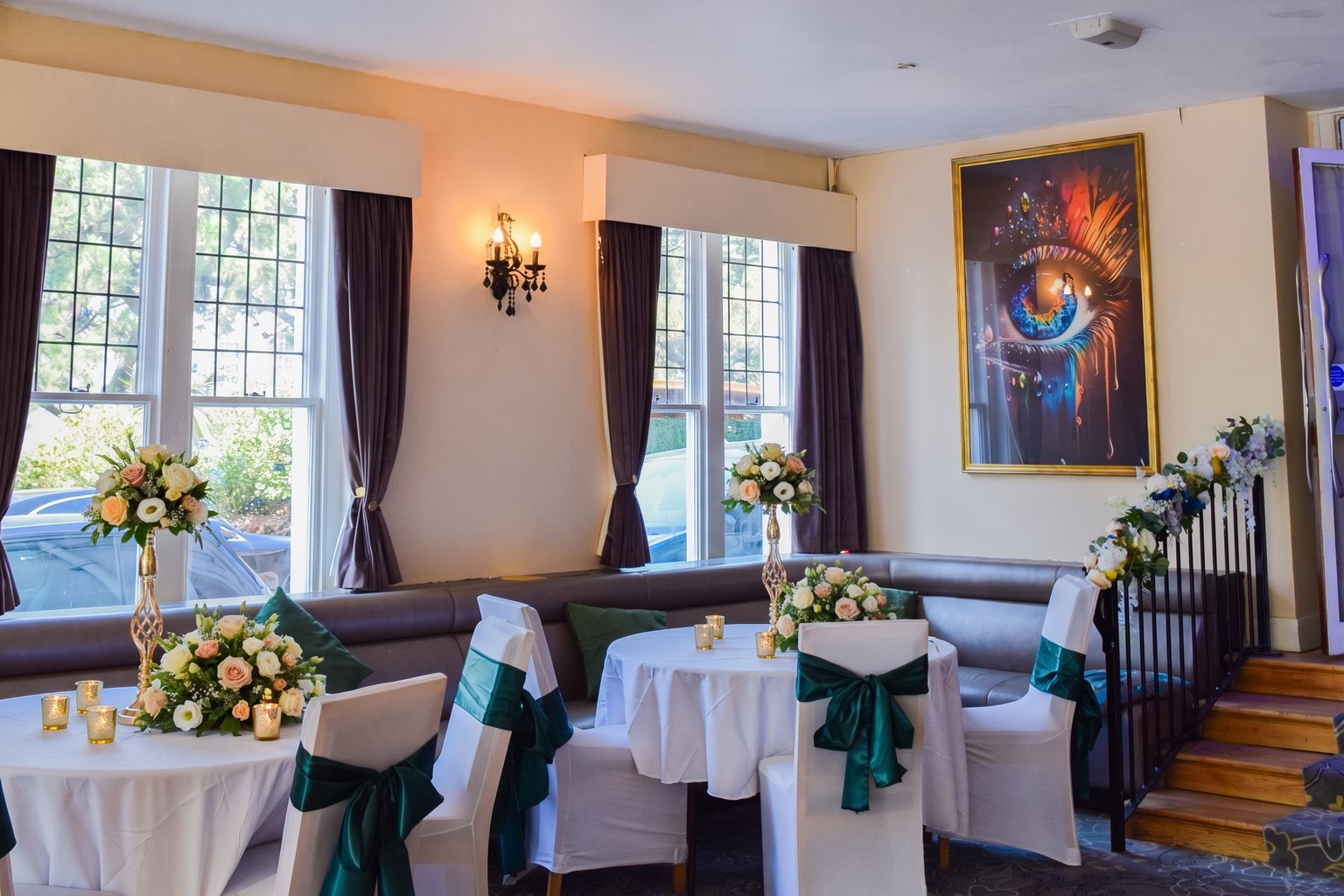 Round tables at Ashbury Lounge dressed with sashes and floral centrepieces