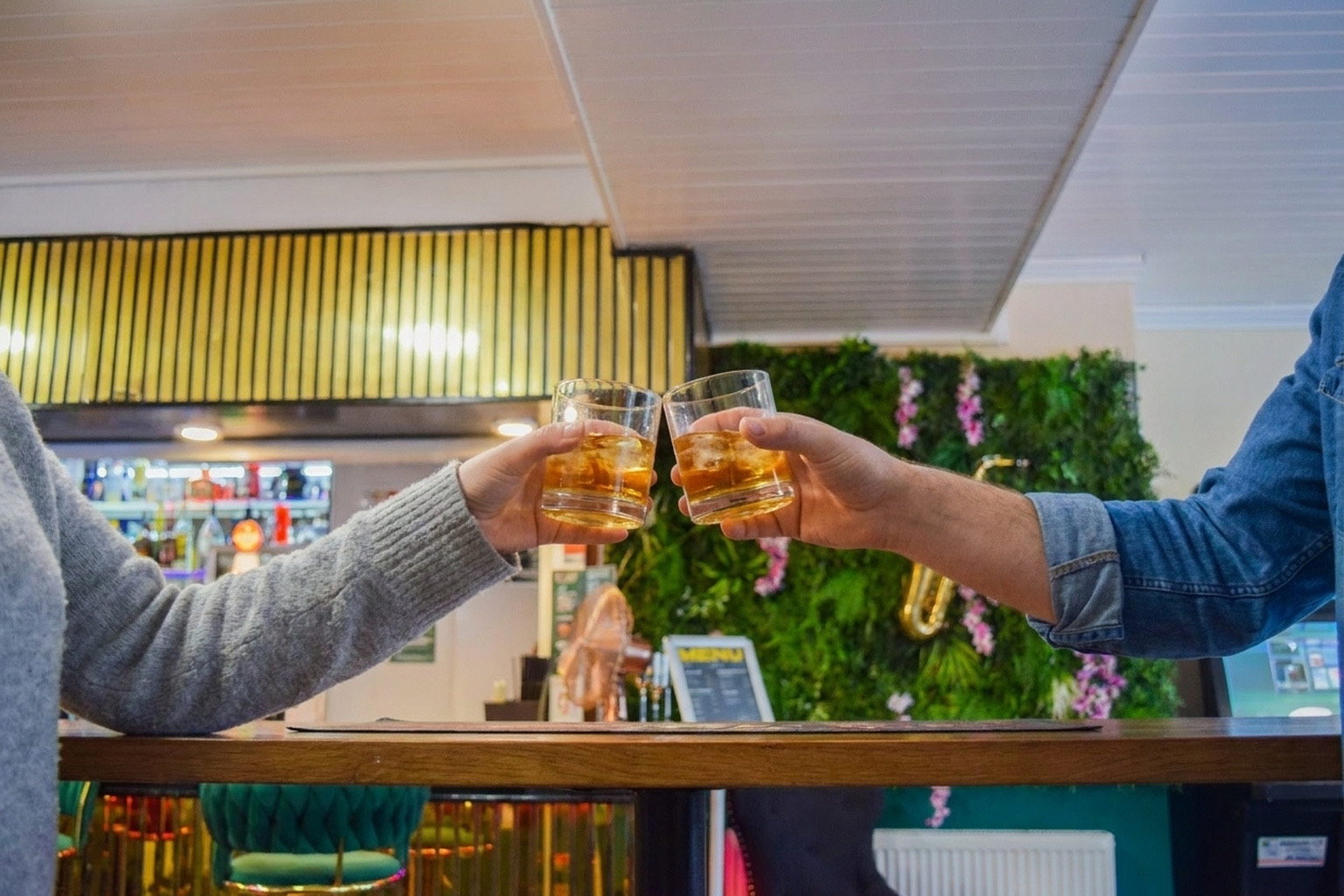 Two guests touching glasses at the bar at Ashbury Lounge