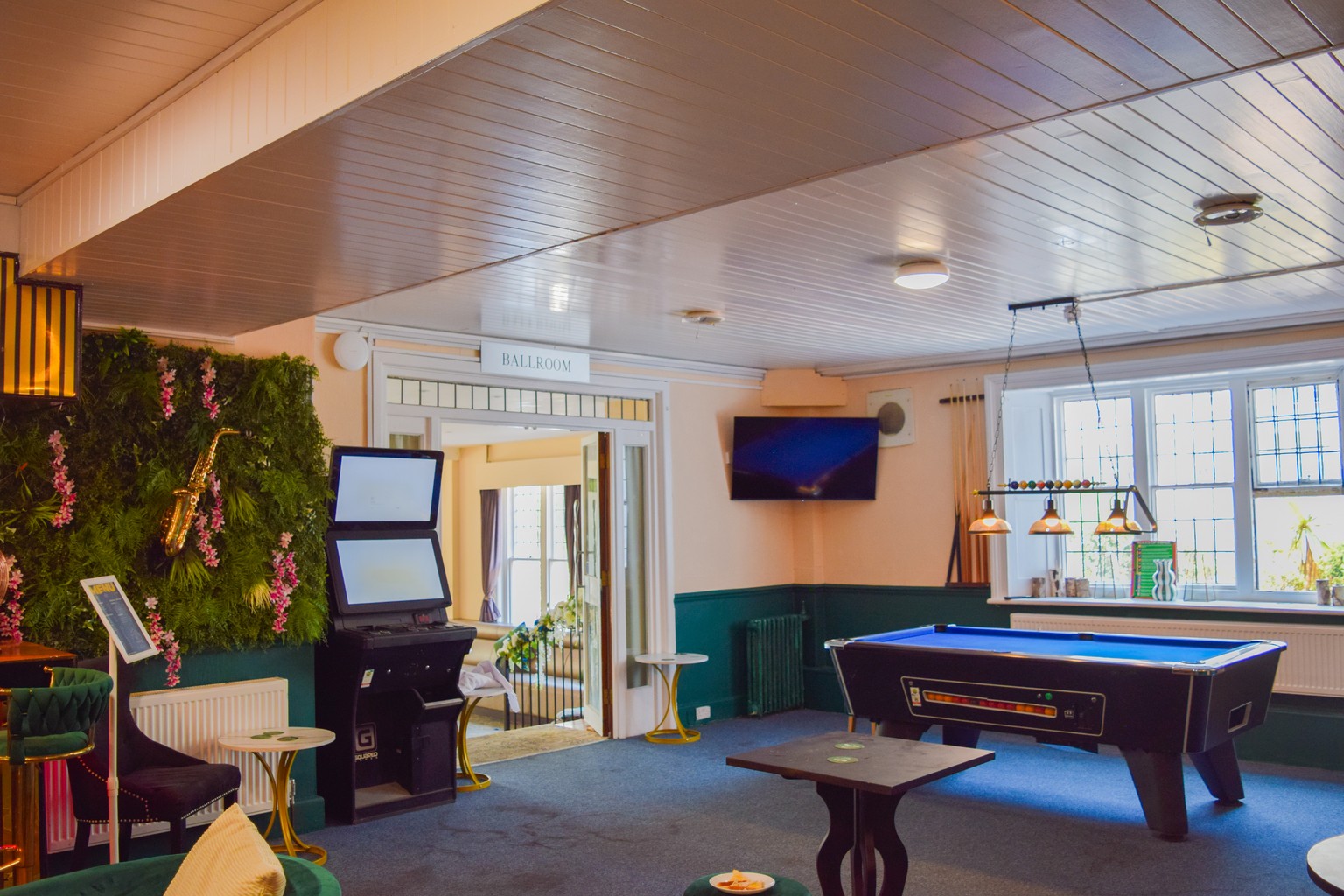 The bar at Ashbury Lounge, with the pool table, a wall-mounted screen and the plant wall